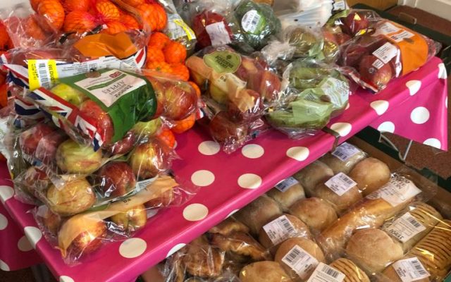 Photo showing a table with fruit, vegetables and bread on top